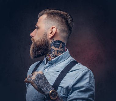Mavi bir gömlek ve pantolon askısı yakışıklı bir eski moda hipster profil. Karanlık bir arka plan üzerinde izole.
