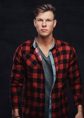 Yakın çekim yakışıklı bir genç adam bir stüdyoda poz bir yün gömlekli portresi. Karanlık bir arka plan üzerinde izole