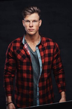 Yakın çekim yakışıklı bir genç adam bir stüdyoda poz bir yün gömlekli portresi. Karanlık bir arka plan üzerinde izole