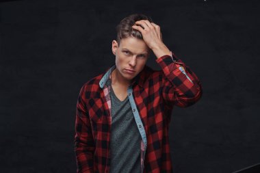 Yakın çekim yakışıklı bir genç adam bir stüdyoda poz bir yün gömlekli portresi. Karanlık bir arka plan üzerinde izole