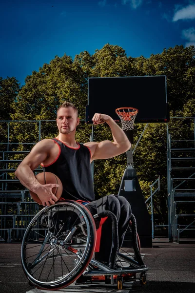オープン ゲーム地面にボールを持った車椅子ポーズで強力なバスケット ボール選手 — ストック写真