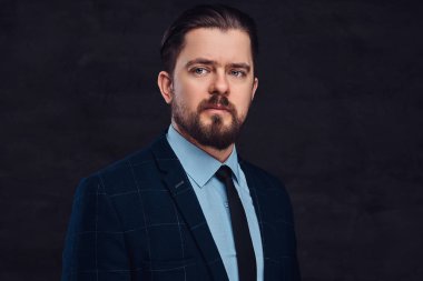 Yakın çekim portre sakal ve saç modeli ile yakışıklı bir orta yaşlı adamın dokulu bir koyu arka plan Studio bir zarif resmi kıyafeti giymiş.