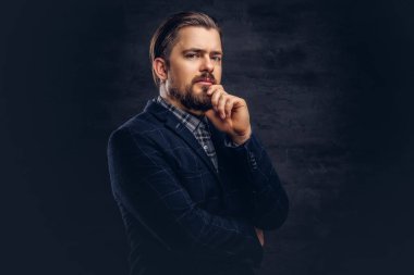 Sakal ve saç modeli ile dalgın orta yaşlı adam Studio dokulu koyu arka plan üzerinde zarif bir mavi elbise giymiş.