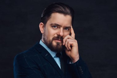 Sakal ve saç modeli ile dalgın orta yaşlı adam Studio dokulu koyu arka plan üzerinde zarif bir mavi elbise giymiş.