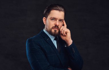 Sakal ve saç modeli ile dalgın orta yaşlı adam Studio dokulu koyu arka plan üzerinde zarif bir mavi elbise giymiş.