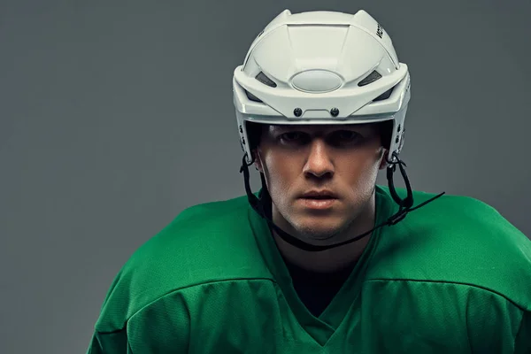 特写肖像的专业曲棍球运动员在保护运动服和头盔 在灰色背景上隔离 — 图库照片