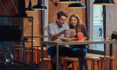 Mutlu çift genç öğrencilerin öğle yemeği sırasında dijital tablet kullanma bir Asya restoran kırmak. 