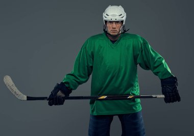 Tam dişli ve hokey sopası giyen profesyonel hokey oyuncusu portresi. Gri bir arka plan üzerinde izole.