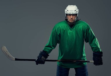 Tam dişli ve hokey sopası giyen profesyonel hokey oyuncusu portresi. Gri bir arka plan üzerinde izole.