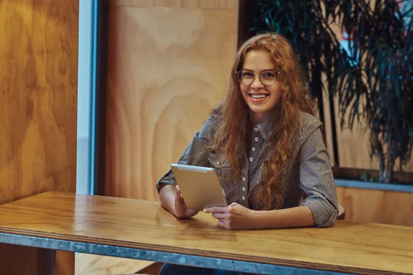 Akıllı Kızıl Saçlı Kıvırcık Kız Öğrenci Gülümseyen Bir Dijital Tablet — Stok fotoğraf