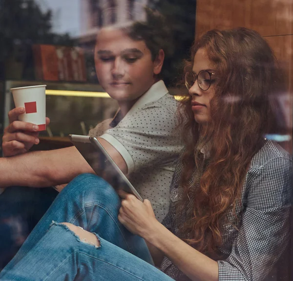 Dos Jóvenes Estudiantes Pensativos Tomando Café Usando Una Tableta Digital —  Fotos de Stock