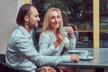 Sarışın kadın yakışıklı çekici çift - beyaz bir bluz giymiş ve bir kafe açık havada bir tarihte sırasında beyaz bir gömlek giymiş şık bir saç kesimi ile erkek sakallı.