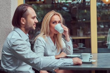 Sarışın kadın yakışıklı çekici çift - beyaz bir bluz giymiş ve bir kafe açık havada bir tarihte sırasında beyaz bir gömlek giymiş şık bir saç kesimi ile erkek sakallı.