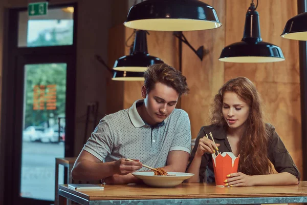 Baharatlı Erişte Asya bir restoranda yemek giyiyor rahat kıyafetler genç çekici çift. 