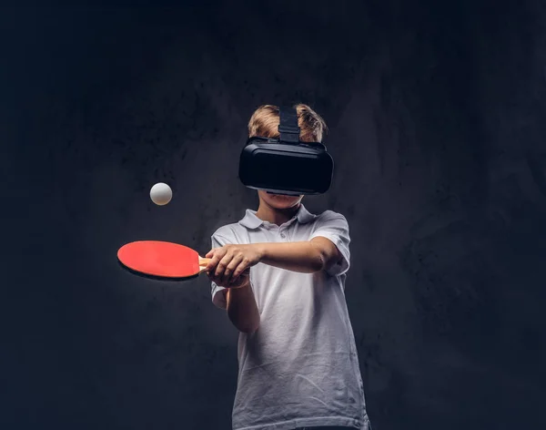 赤毛の少年は 仮想現実の眼鏡と白い シャツの再生卓球に身を包んだ ダーク テクスチャ背景に分離 — ストック写真