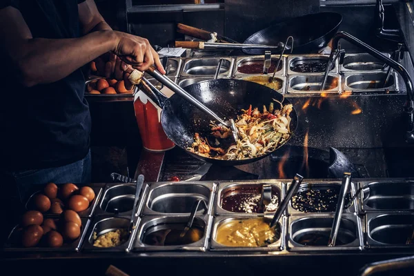 Cook bir wok sebze karıştırma. Asya bir restoranda pişirme işlemi.