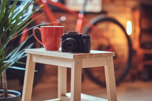 Immagine Ravvicinata Una Tazza Rossa Una Macchina Fotografica Uno Sgabello — Foto Stock