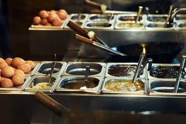 İşyeri Asya bir restoranda bir aşçı. Plaka, wok ve birtakım soslar ve sebze.