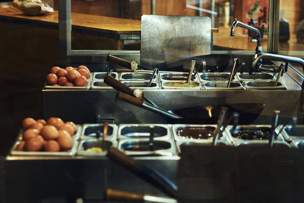 İşyeri Asya bir restoranda bir aşçı. Plaka, wok ve birtakım soslar ve sebze.