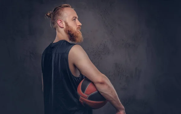 ダーク テクスチャ背景に分離されたボールを保持している黒いスポーツウェアで赤毛のバスケット ボール選手の肖像 — ストック写真