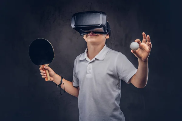 金髪の少年は 仮想現実の眼鏡と白い シャツの再生卓球に身を包んだ ダーク テクスチャ背景に分離 — ストック写真