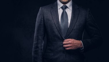Şık takım elbisesi kadar düğmelerini başarılı bir iş adamı kırpılmış portresi. Karanlık bir arka plan üzerinde izole.
