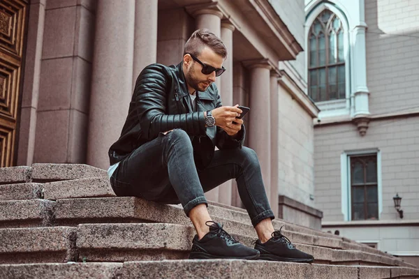 Fashionable Guy Dressed Black Jacket Jeans Using Smartphone Sitting Steps — Stock Photo, Image