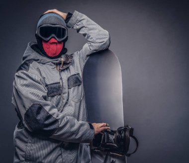 Bir snowboard portresi extream snowboard snowboard bir stüdyoda ile poz tam koruyucu giysiler giymiş. Gri bir arka plan üzerinde izole.