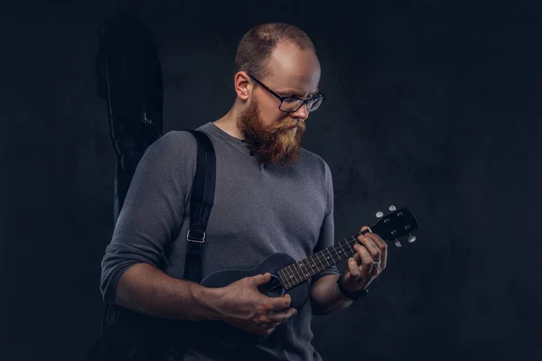 Kızıl Saçlı Gözlüklü Bir Ukulele Üzerinde Oynarken Gri Tişört Giymiş — Stok fotoğraf