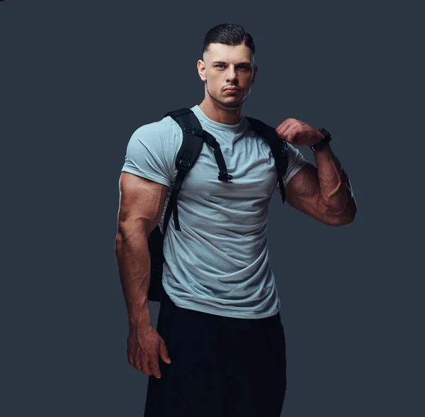Muskulöser Gutaussehender Bodybuilder Sportbekleidung Mit Rucksack Posiert Vor Grauem Hintergrund — Stockfoto