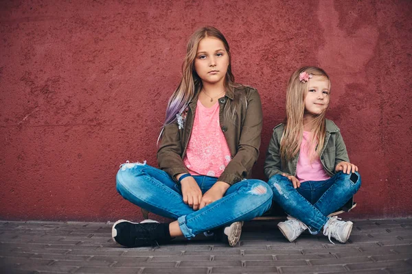 Portrait Two Little Sisters Dressed Trendy Clothes Leaning Wall While — Stock Photo, Image