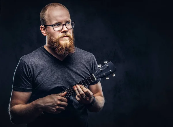 Kızıl Saçlı Gözlüklü Bir Ukulele Üzerinde Oynarken Gri Tişört Giymiş — Stok fotoğraf