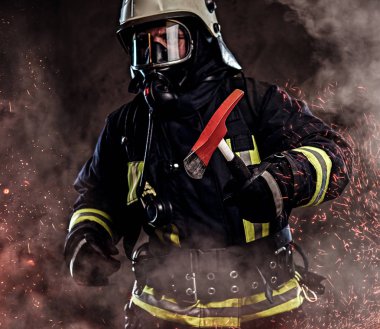 Bir itfaiyeci üniforma ve oksijen maskesi giymiş bir kırmızı balta ayakta yangında kıvılcım ve karanlık bir arka plan üzerinde duman tutar