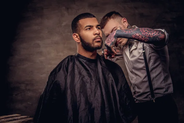 昔ながらの Tattoed プロの美容師による散髪を得て髭があるアフリカ系アメリカ人のヒップスター男はヘアカット — ストック写真