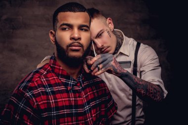 Saçını eski moda bir profesyonel kuaför tarafından Başlarken bir polar gömlekli sakallı Afro-Amerikan hipster adam saç kesimi yapıyor.