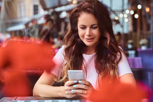 Uzun Kahverengi Saçlı Açık Kafede Otururken Bir Smartphone Kullanarak Bir — Stok fotoğraf