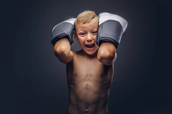 Boxer ragazzo senza maglietta con i capelli biondi indossa guanti da boxe allenamento in uno studio . — Foto Stock