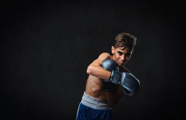Yakışıklı gömleksiz genç boksör boks egzersizleri sırasında ciddi konsantre yüz ile süreci odaklı.