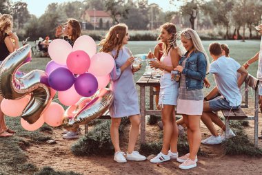 Mutlu kız konuşma piknik partide açık birlikte. Bir Doğum günü kutlamaları park açık sahne.