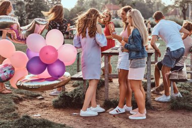 Mutlu kız konuşma piknik partide açık birlikte. Bir Doğum günü kutlamaları park açık sahne.
