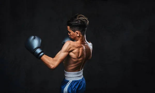 Guapo boxeador joven sin camisa durante los ejercicios de boxeo, centrado en el proceso con serio facial concentrado . — Foto de Stock