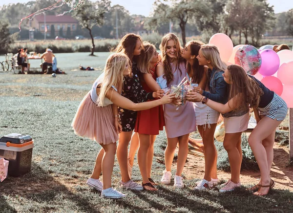 Група подружок розважається разом, святкуючи день народження у відкритому парку. Щасливі друзі вітають з соком на вечірці на відкритому повітрі . — стокове фото