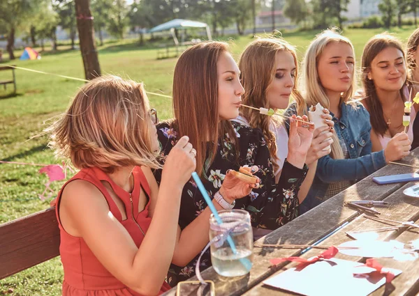 Ομάδα ευτυχισμένος φίλες που τρώνε στο τραπέζι μαζί γιορτάζουν γενέθλια στο υπαίθριο πάρκο. — Φωτογραφία Αρχείου