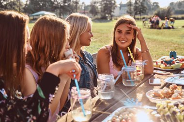 Mutlu kız masada birlikte açık parkta bir Doğum günü kutluyor oturma grubu.