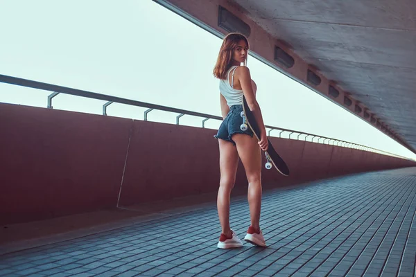 반바지와 관능적인 스케이팅 여자의 스케이트 보드를 카메라를 — 스톡 사진
