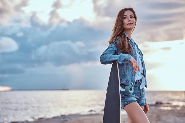 Beautiful Girl Dressed Denim Shorts Jacket Posing Skateboard Beach Cloudy — Stock Photo, Image