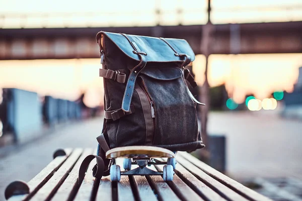 Foto Close Uma Mochila Deitada Skate Que Fica Banco Aterro — Fotografia de Stock