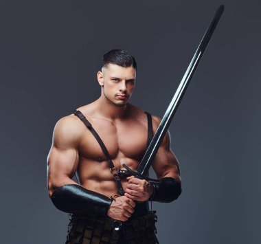 Karanlık bir arka plan üzerinde poz savaş üniformalı bir kas vücut ile acımasız Antik Yunanistan savaşçı