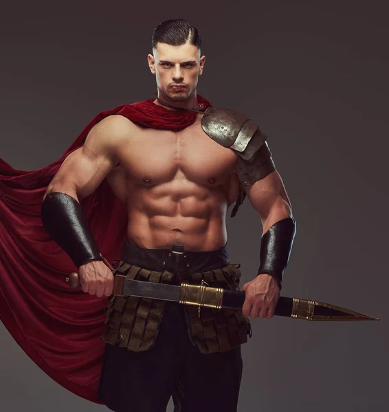 野蛮的古希腊战士 在一个灰色的背景下 在战斗制服的肌肉身体 — 图库照片