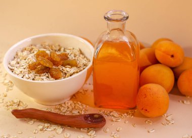 Sağlıklı kahvaltı. Beyaz tabak yulaf ezmesi kuru kayısı, kayısı suyu ve taze kayısı beyaz bir tabloda bir bardak. Yaz hasat.